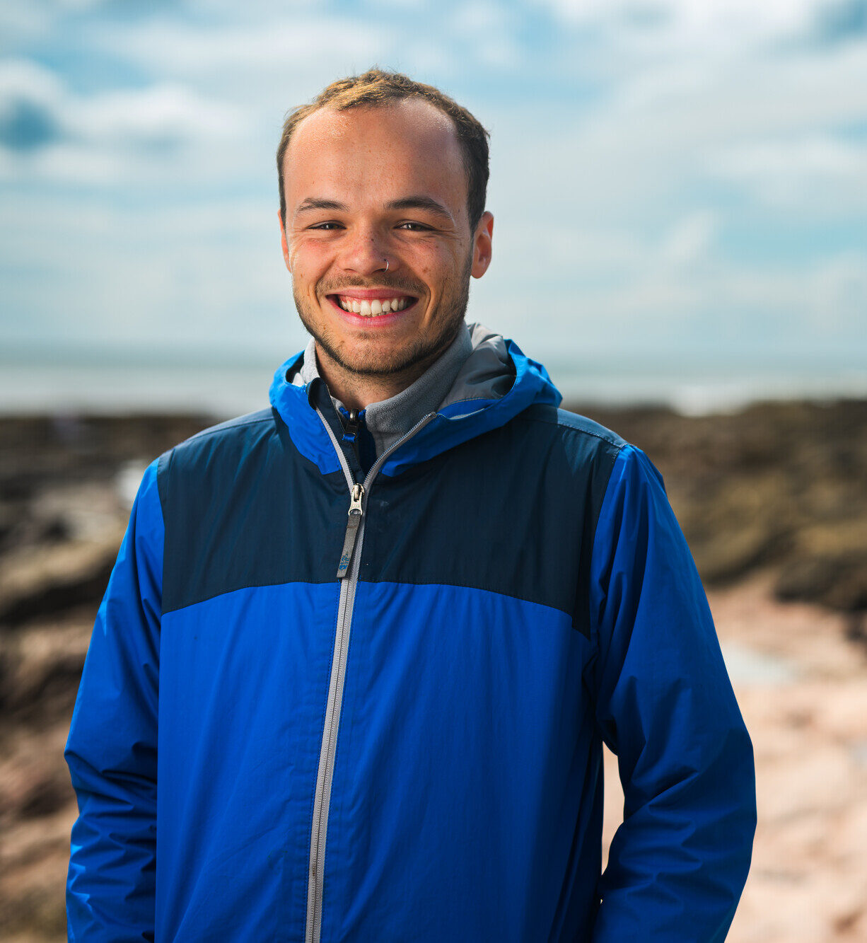 Fraser Brough on the rocky shore smiling
