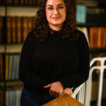 Chloe Figueroa smiling to the camera in the MBA library