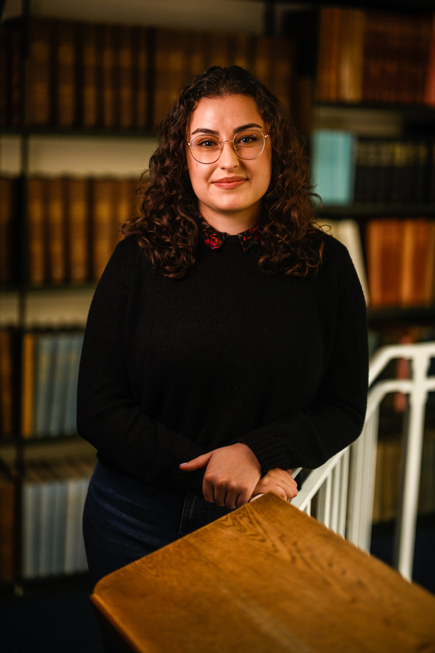 Chloe Figueroa smiling to the camera in the MBA library