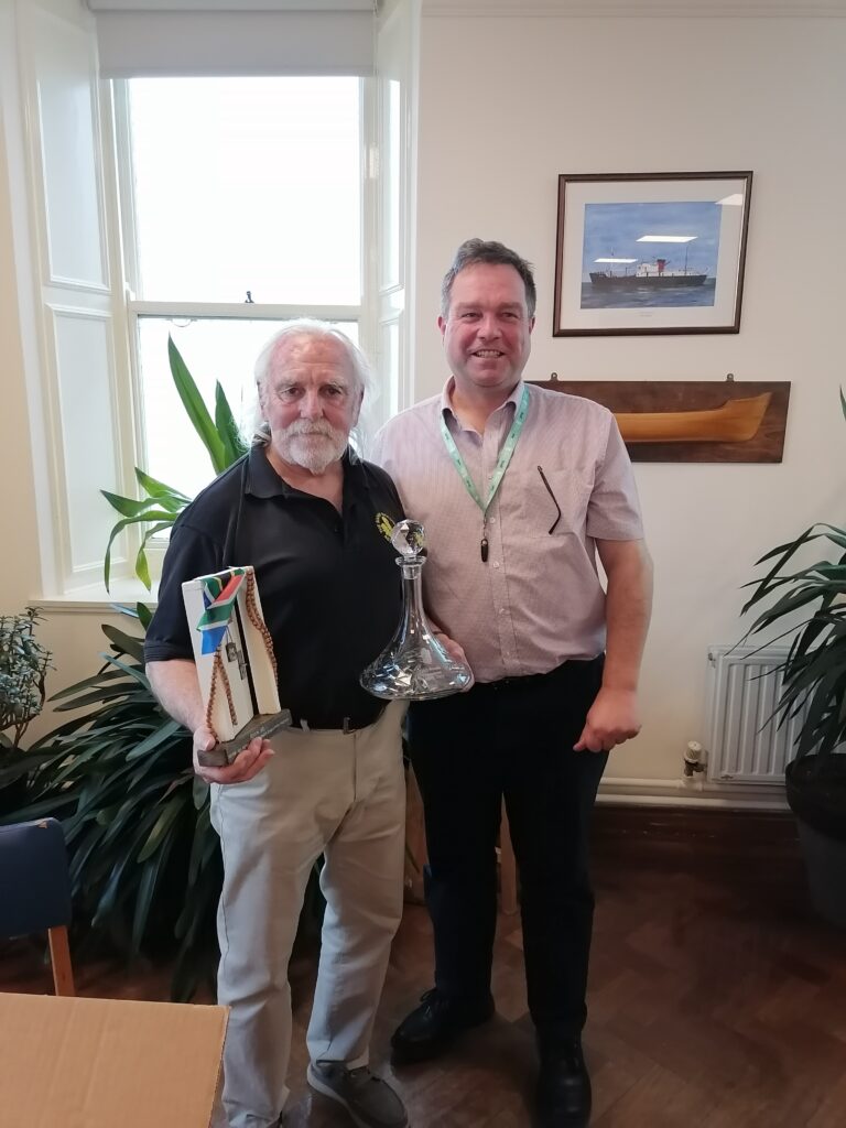 Pete Rendle with farewell gifts presented by CEO Professor Willie Wilson in the Common Room.