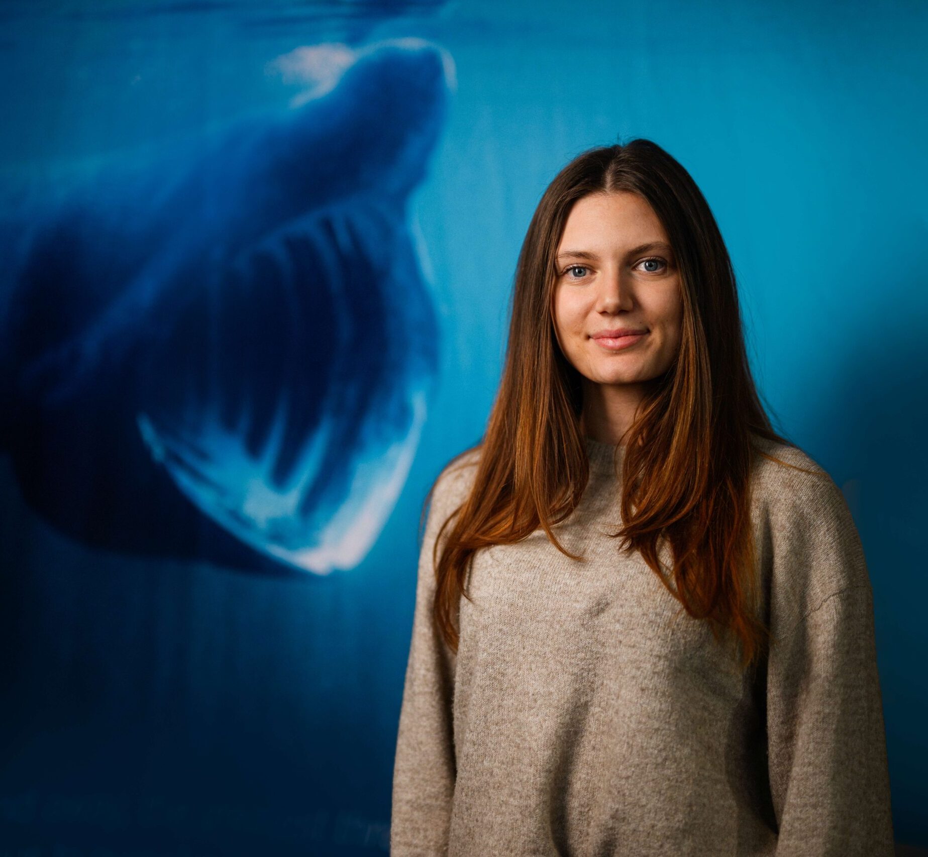 Amy Jeffries smiling with an image of a Basking Shark mouth open behind her