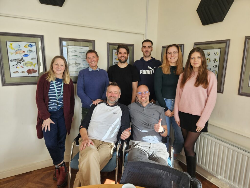 Group photo of the Sims Lab Team in the Alister Hardy Boardroom at the MBA.