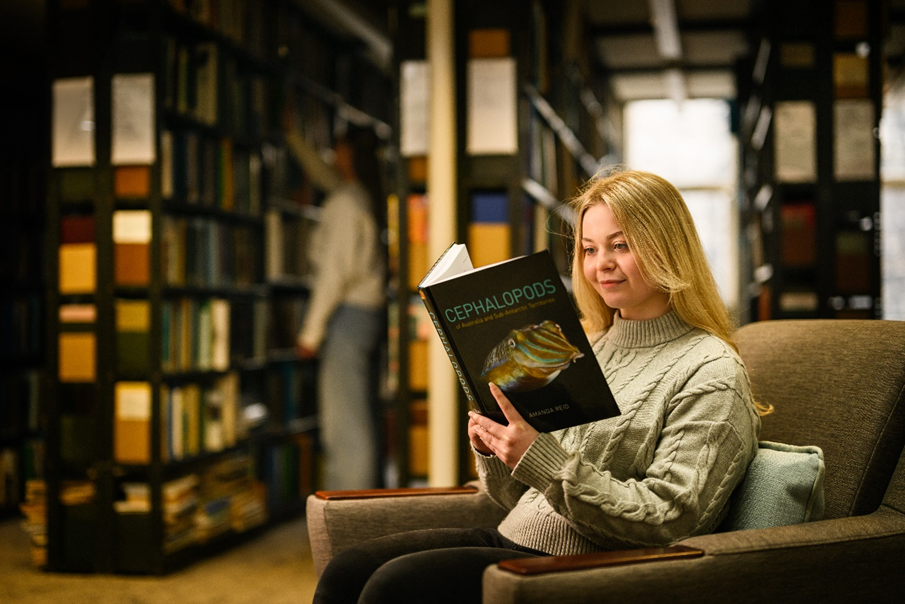 Student reading a book in the Southward Reading room in the library