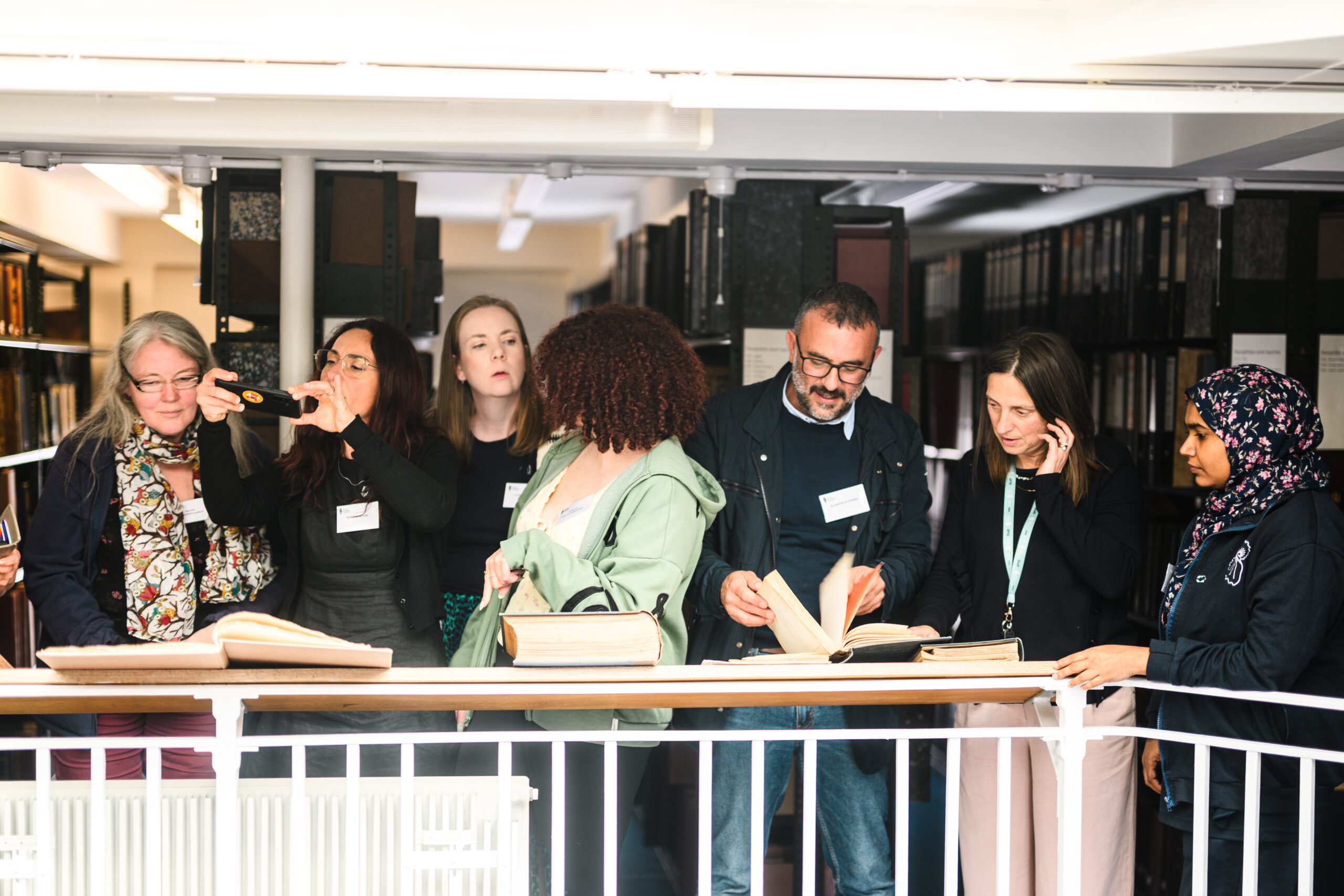 Group of people standing behind white railings on mezzanine level of the National marine Biological Library at the MBA.