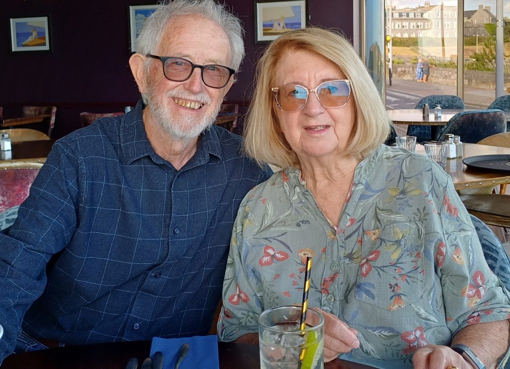 Bernie and Kathy in a restaurant, smiling at the camera.